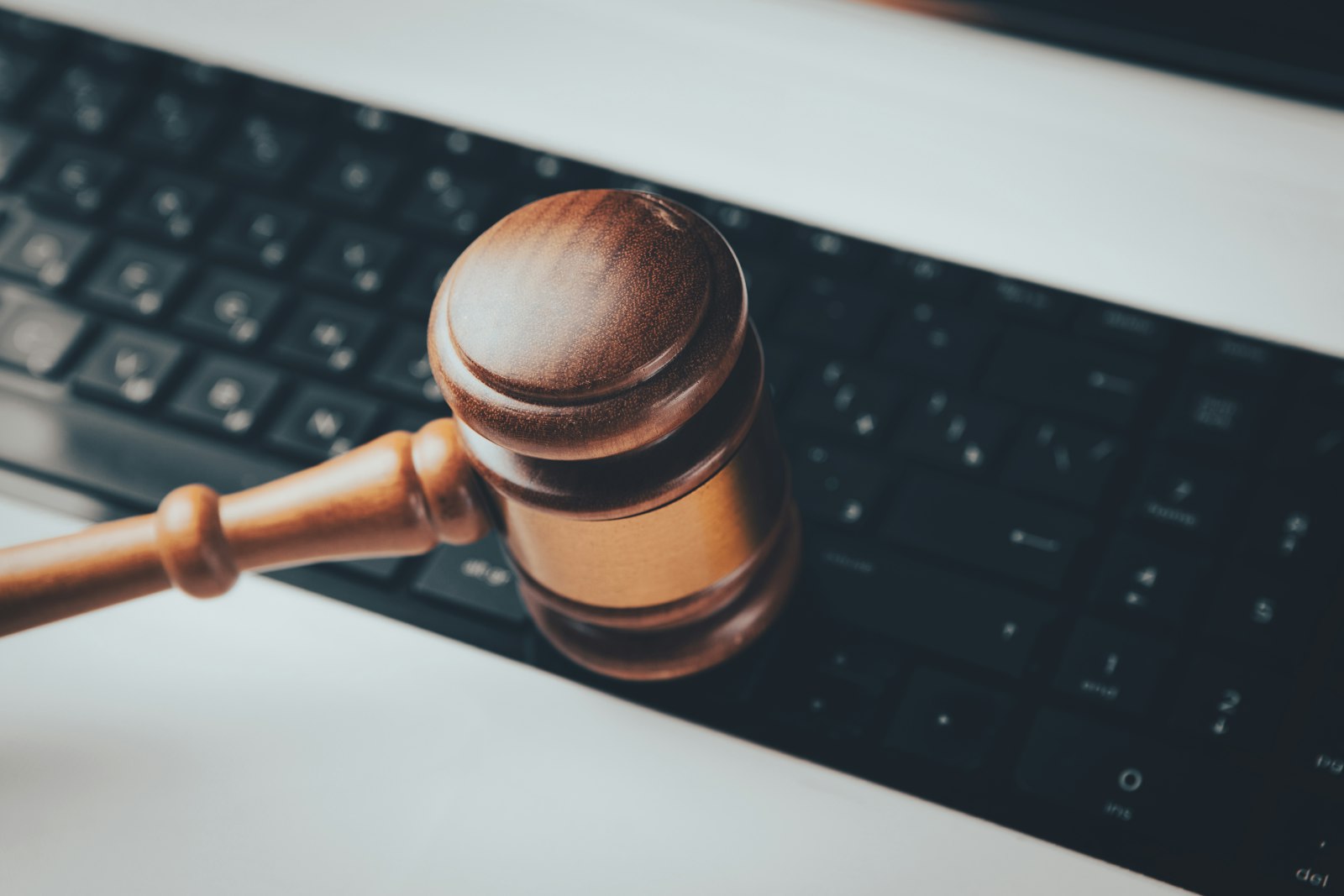 A judge's gavel resting on a keyboard